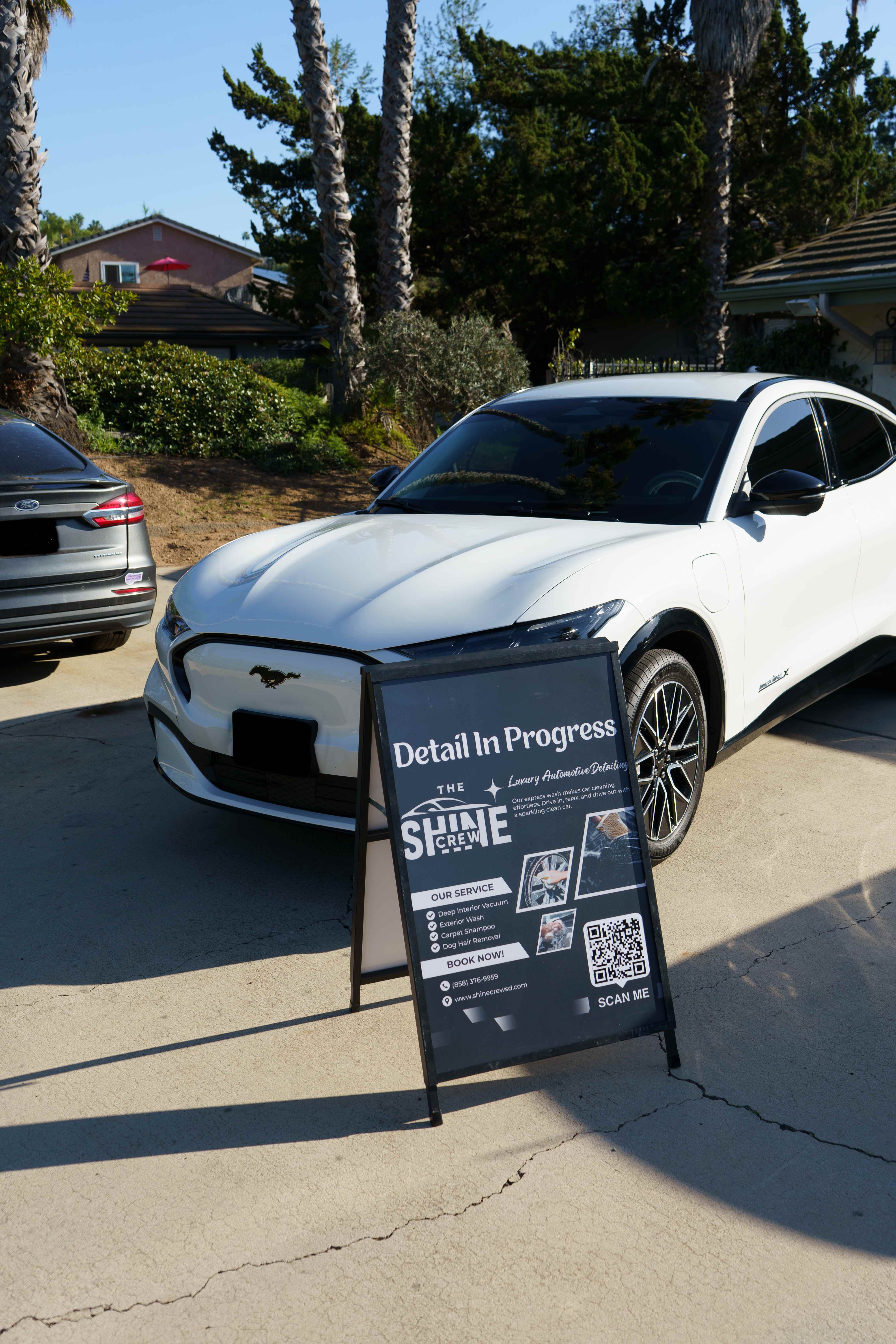 Detail In Progress - White Mustang Mach-E with The Shine Crew sign